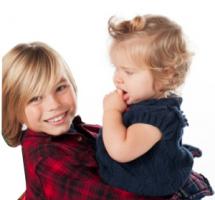 Niño con un bebe en brazos