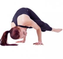 Mujer realizando ejercicios de estiramiento en el suelo. Viste ropa deportiva oscura sobre fondo blanco