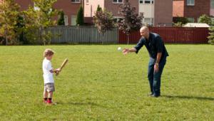 Padre e hijo juegan al beisball en el jardÃ­n de su casa