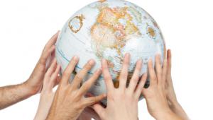 Varias manos sostienen un globo terraqueo