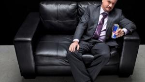 Plano general de un hombre de negocios sentado en un sillon y bebiendo una bebida energÃ©tica