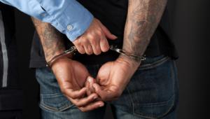 Persona esposada por la policía con las manos a la espalda