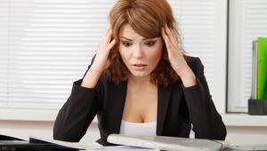 Mujer agobiada frente a su mesa de trabajo