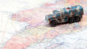 Camino de juguete militar sobre mapa mundi