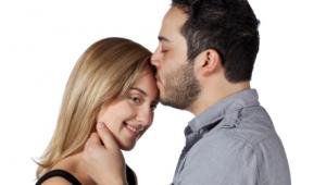 Hombre da un beso cariñoso en la frente de una mujer