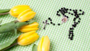 Flores y rosario sobre una mesa mantel