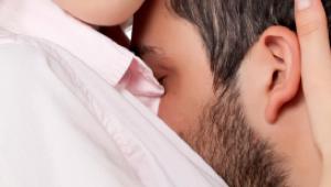 Cara de hombre contra el pecho de una mujer