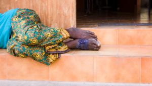 medio cuerpo de mujer tendido sobre el rellano de una escalera