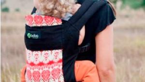 madre cargando a su bebe en una mochila portabebes