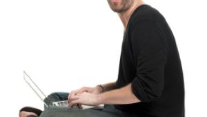 Hombre sorprendido con el ordenador entre sus piernas