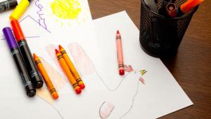 Materiales de pintura y dibujo de un niÃ±o con la silueta de una mano