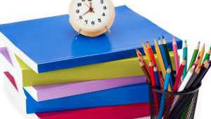 BodegÃ³n de material escolar con un reloj encima de los libros