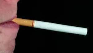 Cara de perfil con un cigarrillo en la boca sobre fondo negro