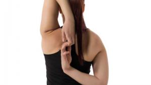 Mujer de espaldas realizando estiramientos de brazos sobre fondo blaco