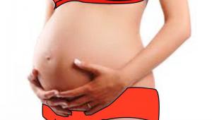 Mujer embarazada se agarra su tripa sobre fondo blanco