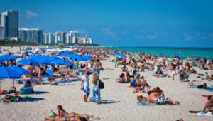 General de una playa repleta de gente, muchos tumbados tomando el sol
