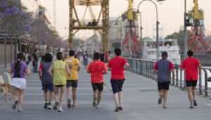 Un grupo de personas jÃ³venes corre por un paseo de un centro urbano