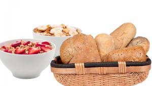 Bodegon con una cesta llena de pan y dos cuencos con cereales y frutas
